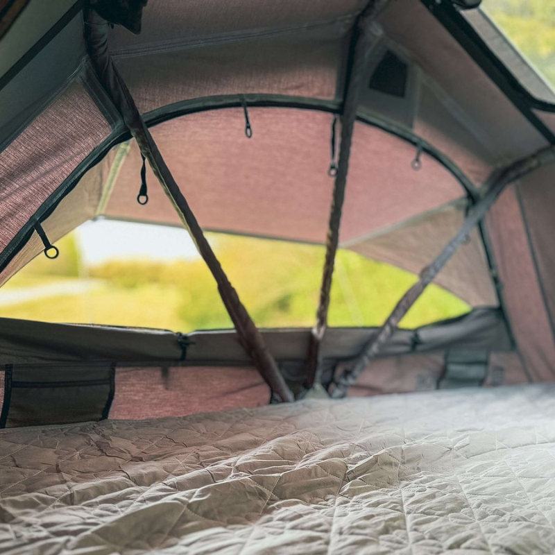 Camping tent interior with a view of greenery outside